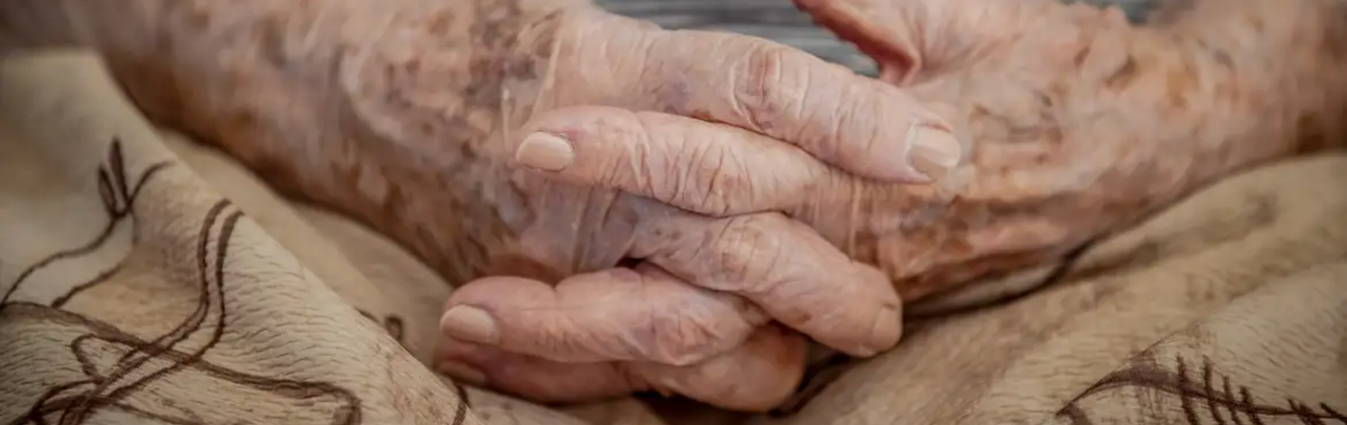 Imagem em close up de mãos de idosos entrelaçadas