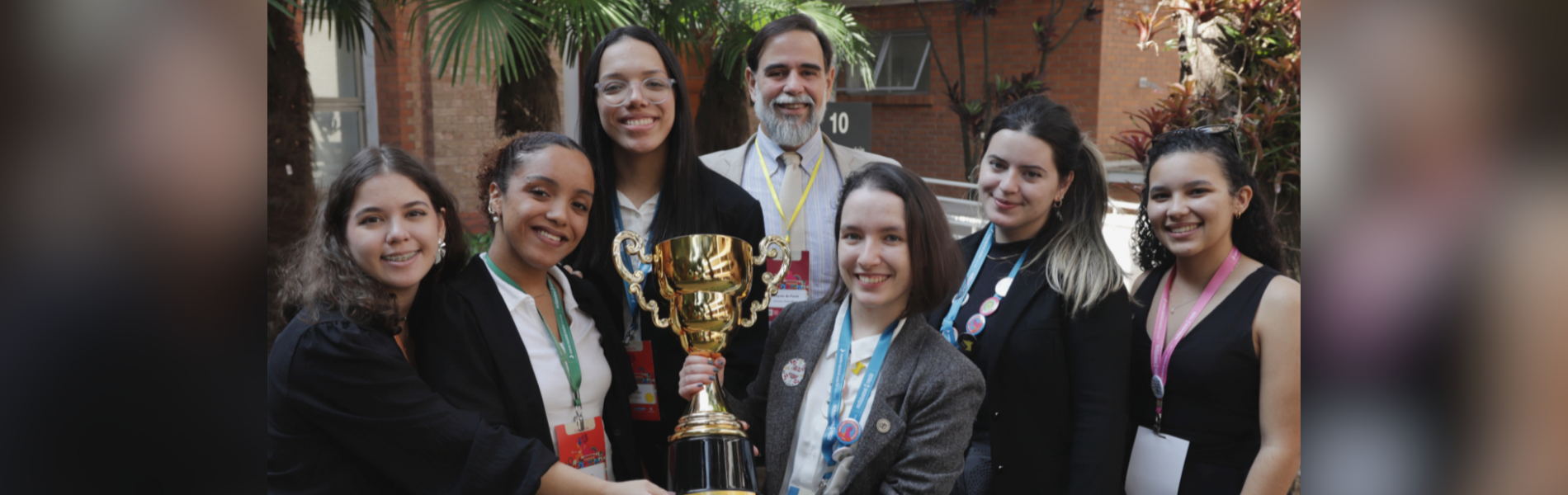 Grupo de estudantes da Enactus segurando taça da premiação