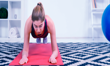 Mulher realizando exercício de "prancha" sobre tapete de yoga
