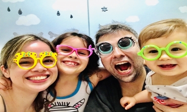 Foto do servidor Eduardo ao lado da esposa e das suas duas filhas com óculos coloridos e divertidos