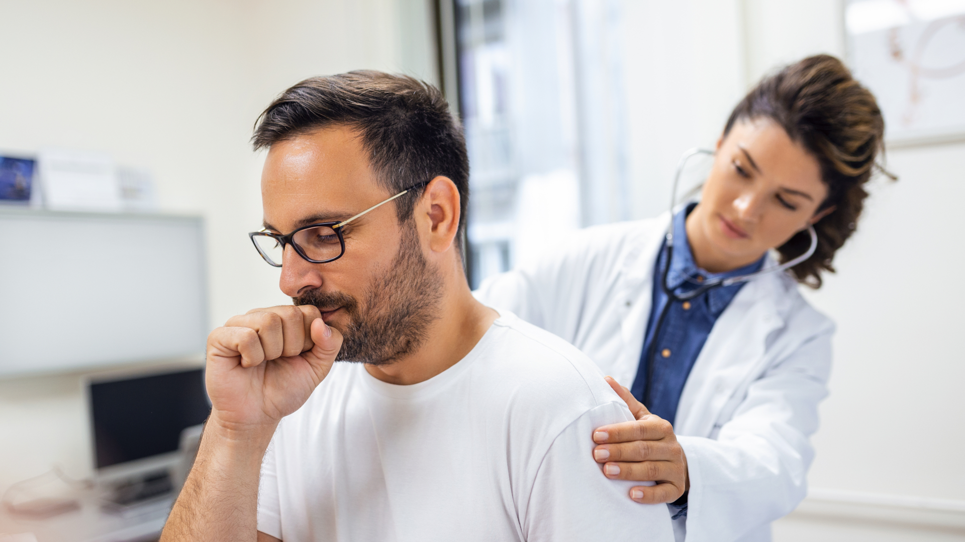 Homem com tosse sendo examinado por médica.