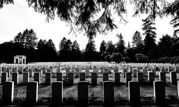 Imagem em P&B de várias lápides em um cemitério