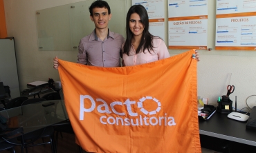 Matheus Dassie e Érica Costa segurando bandeira da Pacto Consultoria Foto: Gabriella Balestrero